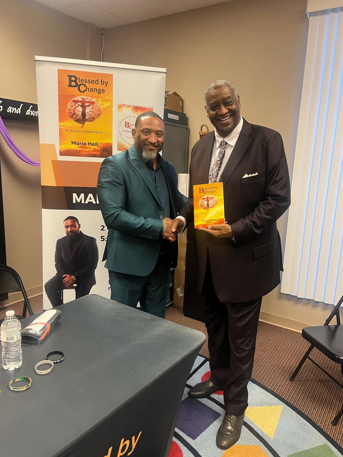 Mario Hall at book signing event with community leaders